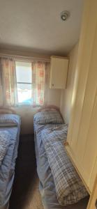 two beds in a small room with a window at The salsbury lyons robin hood park,rhyl in Meliden