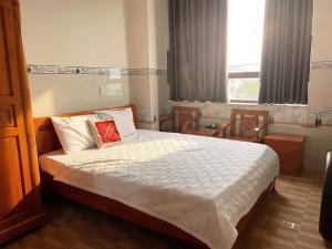 a bedroom with a bed with a red pillow on it at Mimosa 7 Hotel - Phan Rang in Phan Rang–Tháp Chàm