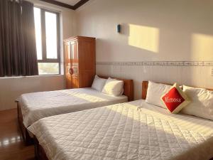 two beds in a room with two beds sidx sidx sidx sidx at Mimosa 7 Hotel - Phan Rang in Phan Rang–Tháp Chàm