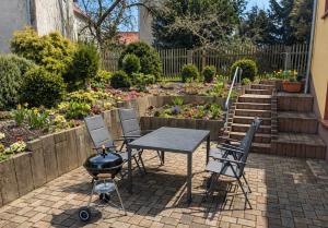 a patio with a grill and chairs and a garden at Urlaubsmagie - Ferienwohnung Libelle - direkt am Wanderweg - L5 in Sebnitz
