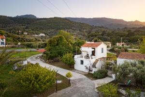 an aerial view of a white house with mountains in the background at Thalia's Cottage - Cozy, Romantic Retreat with Sea & Mountain views in Kámpos