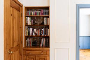 a book shelf filled with books next to a door at Maison Hôte in Magog-Orford