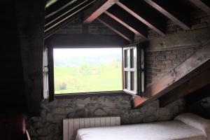 a window in a room with a bed and a brick wall at La Venta de Quijas in Quijas