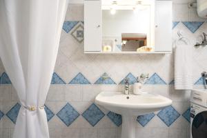 a bathroom with a sink and a mirror at Thalia's Cottage - Cozy, Romantic Retreat with Sea & Mountain views in Kámpos +16 photos
