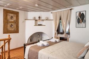 a bedroom with a bed and a fireplace at Thalia's Cottage - Cozy, Romantic Retreat with Sea & Mountain views in Kámpos