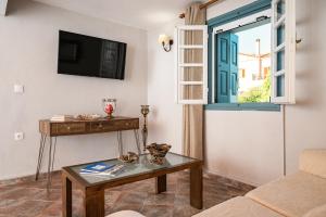 a living room with a table and a window at Thalia's Cottage - Cozy, Romantic Retreat with Sea & Mountain views in Kámpos