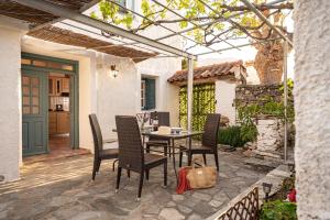 a patio with a table and chairs under a pergola at Thalia's Cottage - Cozy, Romantic Retreat with Sea & Mountain views in Kámpos