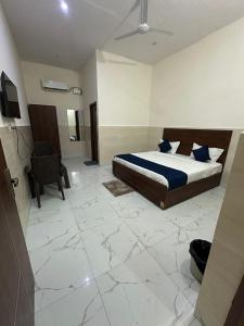a bedroom with a bed and a chair in it at Hotel Gold in Faridabad