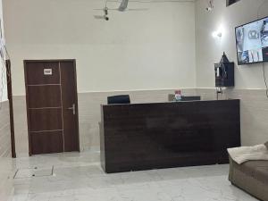 a lobby with a bar with a door and a television at Hotel Gold in Faridabad