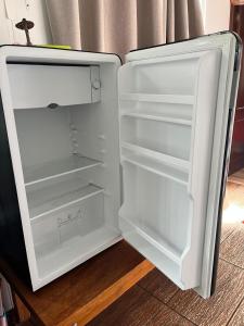 an empty refrigerator with its door open with its door open at La pausa in Piriápolis