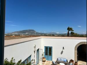 a white building with a blue door and a couch at Relais Antiche Saline in Torre Nubia