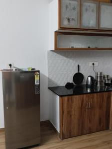 a kitchen with a stainless steel refrigerator and a counter at Aditi Residency in Cochin
