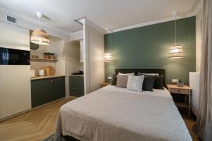 a bedroom with a bed and a green wall at Milla Apartamenty 102 in Zamość +3 photos