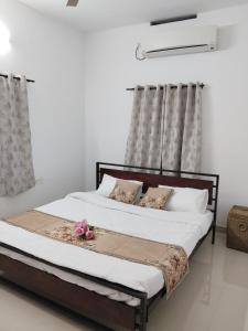 two beds in a white room with flowers on them at Aditi Residency in Cochin