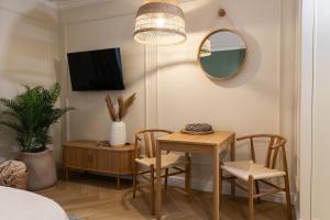 a dining room table with two chairs and a mirror at Milla Apartamenty 102 in Zamość