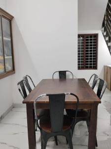 a wooden table with four chairs around it at Aditi Residency in Cochin +18 photos