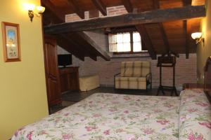 a bedroom with a bed and a chair in a room at La Venta de Quijas in Quijas