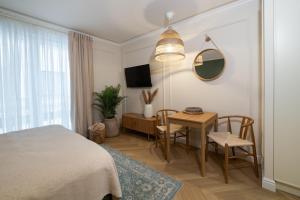 a bedroom with a bed and a table with chairs at Milla Apartamenty 102 in Zamość