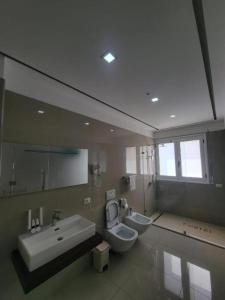 a bathroom with two toilets and a sink and a mirror at Hotel Lusini in Vlorë