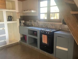 a kitchen with a black stove and a window at Takasira Appart Hôtel Downtown in Fort Dauphin