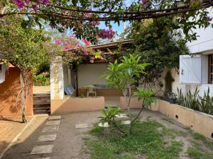 a house with a garden with trees and flowers at Takasira Appart Hôtel Downtown in Fort Dauphin