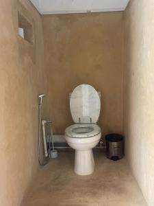a bathroom with a white toilet in a room at Takasira Appart Hôtel Downtown in Fort Dauphin