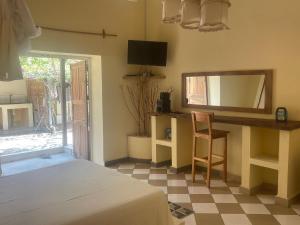 a bedroom with a bed and a desk and a mirror at Takasira Appart Hôtel Downtown in Fort Dauphin