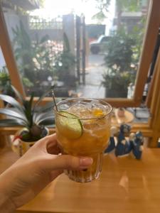 a person holding a drink in a glass on a table at Victoria home in Vĩnh Thái