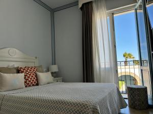 a bedroom with a bed and a large window at Relais Antiche Saline in Torre Nubia +62 photos