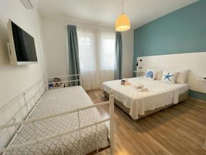 a bedroom with a bed and a flat screen tv at Alicante Otel - Adult Only in Bozcaada