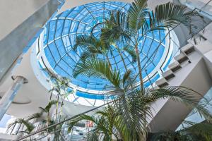 a building with a glass dome and a palm tree at Elba Premium Suites - Adults Only in Playa Blanca