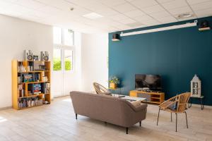 a living room with a couch and chairs and a tv at Le Rayon de Soleil in Châtelaillon-Plage