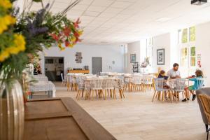 a group of people sitting at tables in a dining room at Le Rayon de Soleil in Châtelaillon-Plage