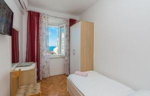 a small bedroom with a bed and a window at Kuća za odmor Katini dvori in Novalja