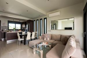 a living room with a couch and a table at Ixia Pool Villa with sea view roof top in Ixia