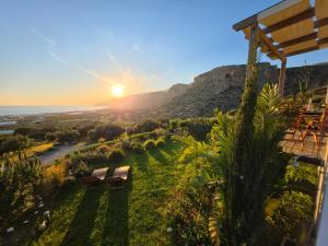 a bench on a hill with the sunset in the background at Casa di Olive Luxury Secluded Sea View Villa in South Crete in Goúdhouros