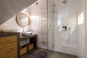 ザコパネにあるApartamenty Pod Giewontem Lux&Spa Zakopaneのバスルーム(ガラス張りのシャワー、シンク付)