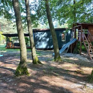 a house with a slide and a playground at Jeziorskie Zacisze & balia in Łyszkowice