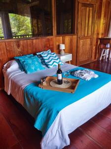 a bed with a tray with a bottle of wine on it at The Temple I, Mindo in Mindo