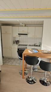 a kitchen with a wooden table and black chairs at Ferienwohnung Daliah in Wangels