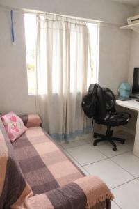 a room with a bed and a desk and a chair at Apartamento 2 quartos Centro de Araranguá in Araranguá