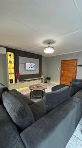 a living room with a large couch and a table at TinasRose in Uvongo Beach