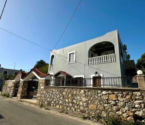 ein Haus auf einer Steinmauer mit Balkon in der Unterkunft Evis' House in Khoríon