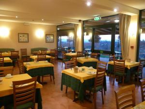 a dining room with tables and chairs and windows at Sangallo Park Hotel in Siena