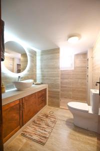 ein Badezimmer mit Waschbecken, Toilette und Spiegel in der Unterkunft Evis' House in Khoríon + 57 Fotos