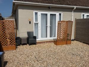 a house with two chairs in front of a door at Starfish Snug in Brixham +2 photos