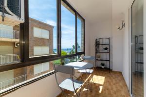 a room with a table and chairs and large windows at Unique Apartahotel 2-3 in Torrevieja