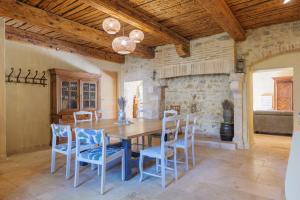 a dining room with a wooden table and chairs at Chambres D’hôtes - Les Agrions in Saint-Remèze