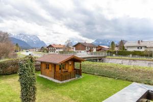 a wooden cabin in a yard with mountains in the background at Ferienwohnung 1 in Wallgau