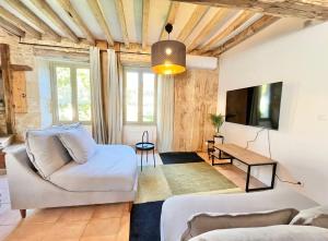 a living room with a couch and a tv at Baolocation Bouhy - Idéal famille & groupe d'amis -16min Guédelon - Wifi in Bouhy